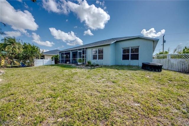 back of house with a sunroom and a lawn