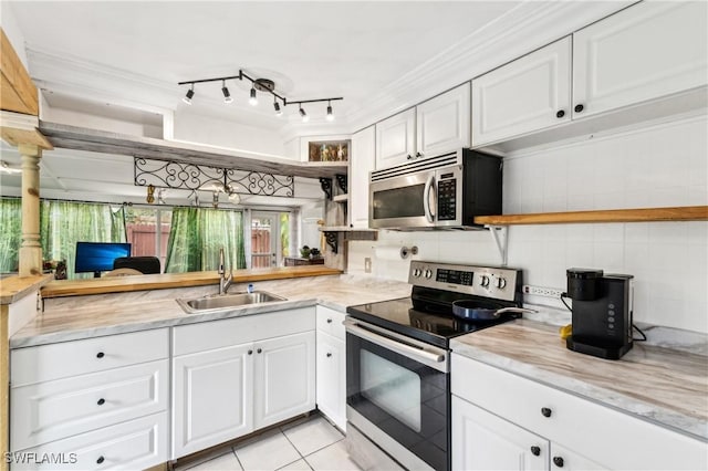 kitchen featuring stainless steel appliances, open shelves, a sink, and white cabinetry