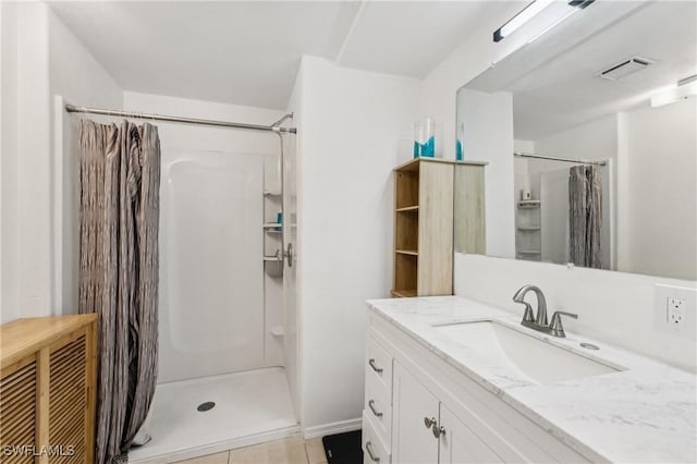 bathroom with tile patterned floors, vanity, visible vents, and a shower stall