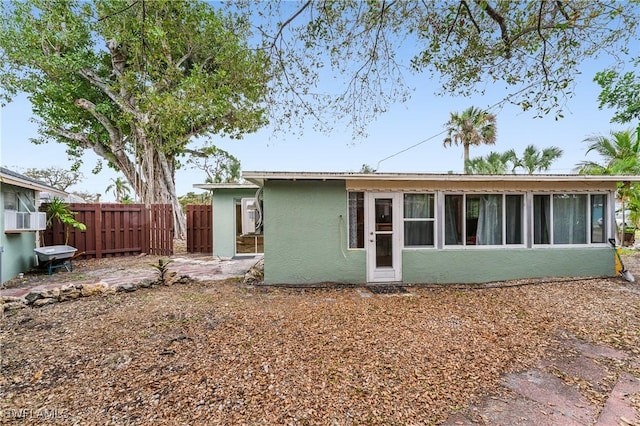 back of property featuring fence and stucco siding