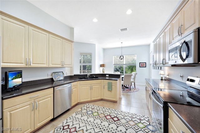 kitchen with sink, light tile patterned floors, hanging light fixtures, and appliances with stainless steel finishes