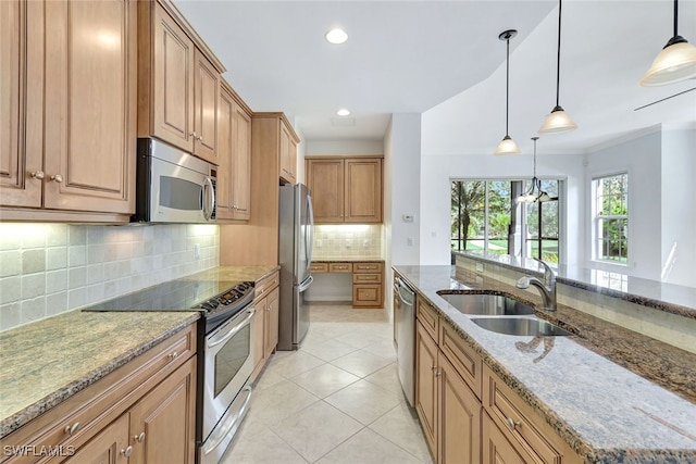 kitchen featuring appliances with stainless steel finishes, sink, hanging light fixtures, light tile patterned floors, and light stone counters