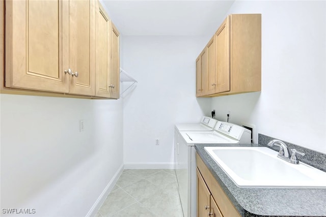 laundry room with cabinets, separate washer and dryer, sink, and light tile patterned floors