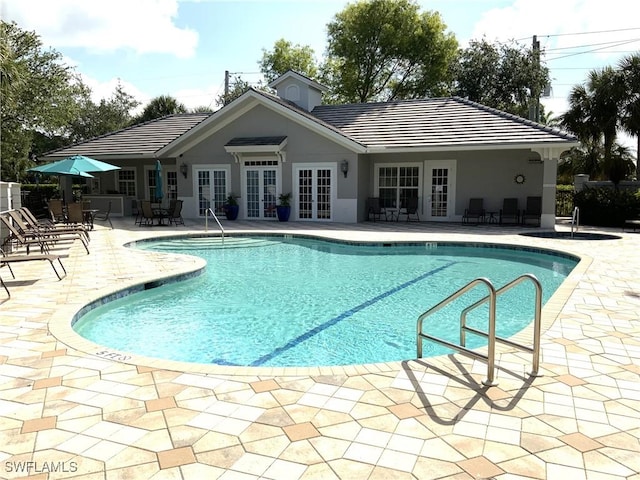 view of swimming pool featuring a patio and french doors