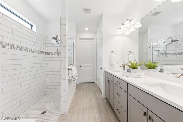 bathroom with vanity and tiled shower