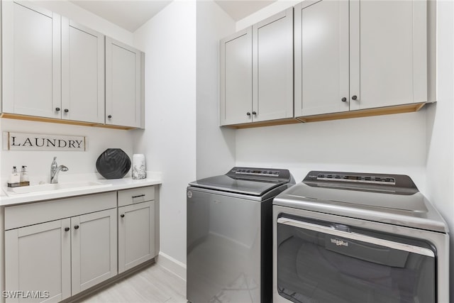 laundry room with separate washer and dryer, sink, and cabinets