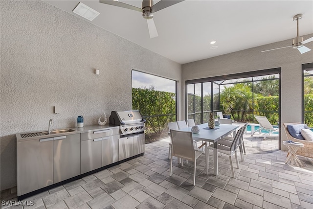 interior space featuring sink, ceiling fan, glass enclosure, a grill, and an outdoor kitchen