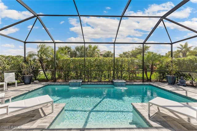 view of pool with a patio area, pool water feature, and glass enclosure