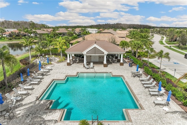 view of swimming pool with a water view and a patio