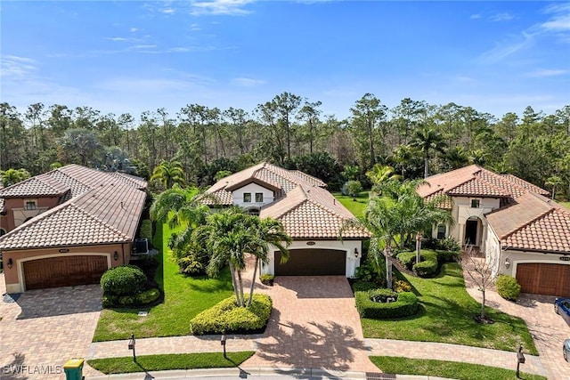 6231 Brunello Ln, Naples, FL 34113 - mediterranean / spanish house with a garage, decorative driveway, a tile roof, and stucco siding