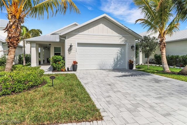 single story home featuring board and batten siding, a front yard, decorative driveway, and an attached garage