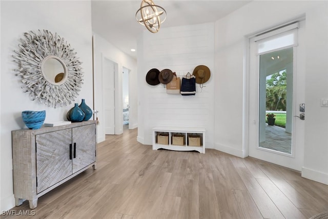 interior space featuring a chandelier, light wood-style flooring, and baseboards