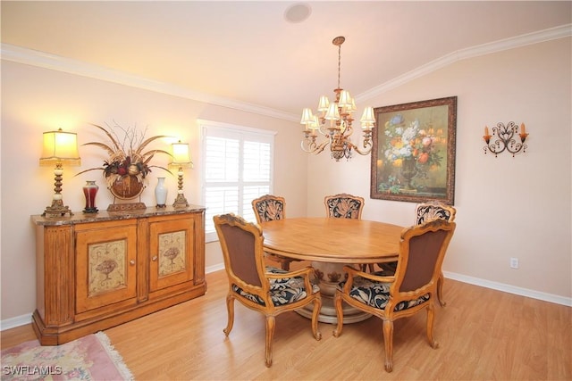 dining room featuring crown molding, vaulted ceiling, an inviting chandelier, and light wood-type flooring