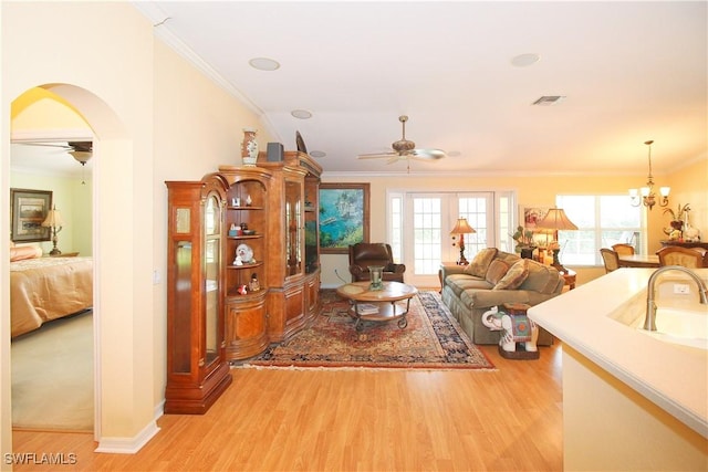 living room with sink, ceiling fan with notable chandelier, and light hardwood / wood-style flooring