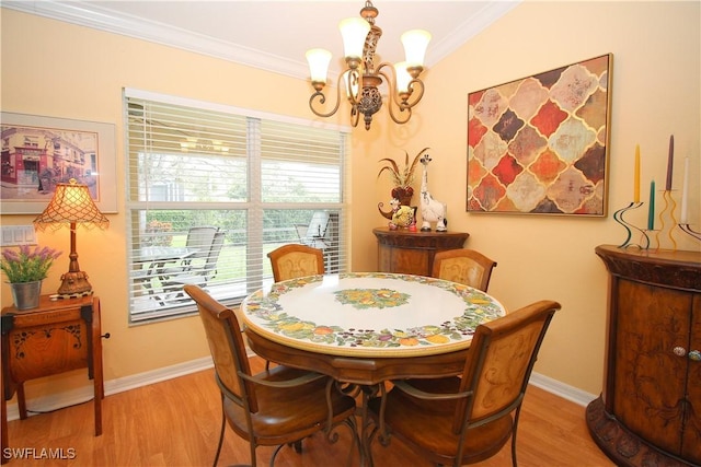 dining area with crown molding, light hardwood / wood-style floors, and a chandelier