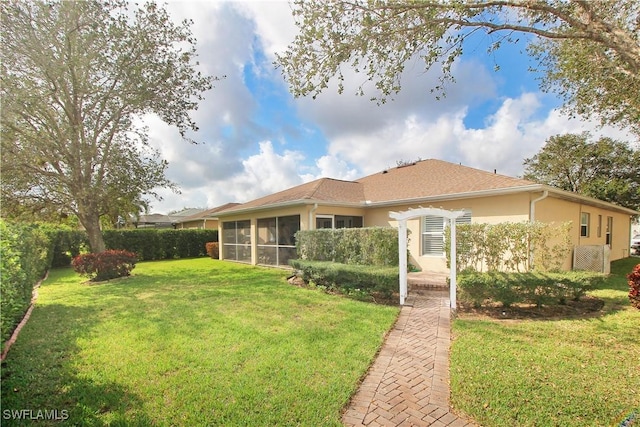 back of property with a yard and a sunroom