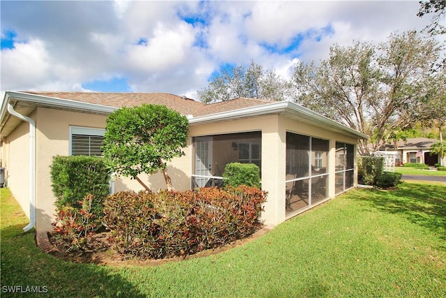 view of property exterior featuring a lawn and a sunroom