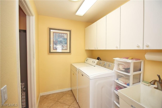 washroom featuring light tile patterned flooring, cabinets, washer and clothes dryer, and sink