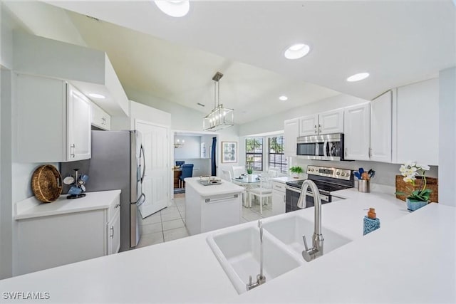 kitchen featuring white cabinets, appliances with stainless steel finishes, hanging light fixtures, light countertops, and light tile patterned flooring