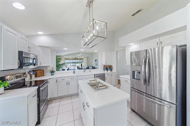 kitchen with appliances with stainless steel finishes, light countertops, white cabinets, and a kitchen island