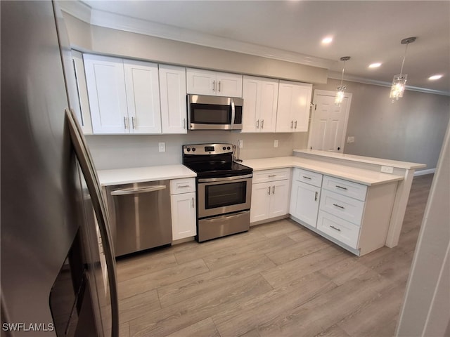 kitchen featuring a peninsula, white cabinetry, light countertops, appliances with stainless steel finishes, and pendant lighting