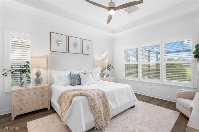 bedroom with crown molding, ceiling fan, a tray ceiling, and dark hardwood / wood-style flooring