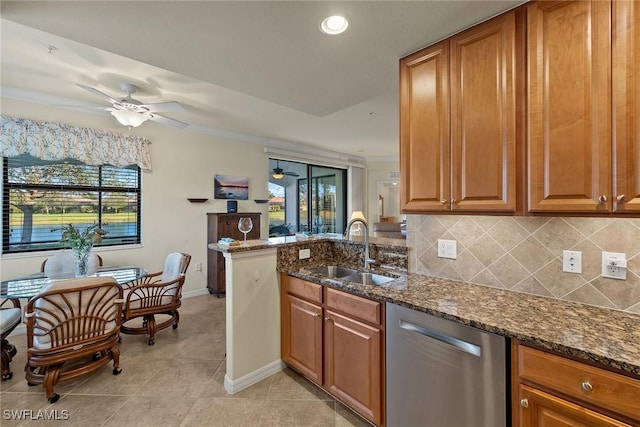 kitchen featuring brown cabinetry, a sink, backsplash, and dishwasher