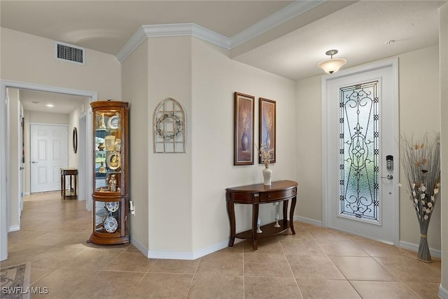 entryway featuring light tile patterned floors, baseboards, visible vents, and ornamental molding