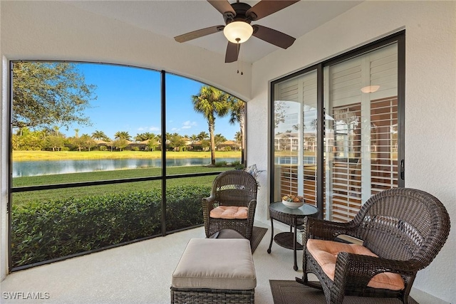 sunroom featuring a water view and ceiling fan