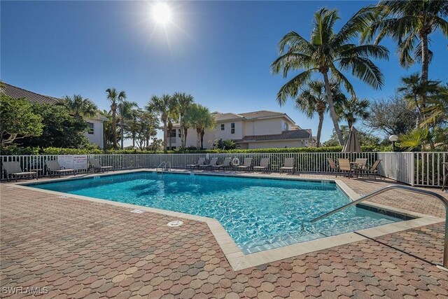 community pool featuring a patio area and fence