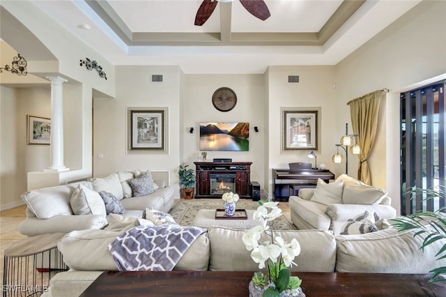 tiled living room featuring ceiling fan and ornate columns