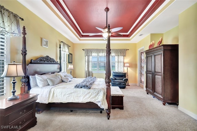 bedroom featuring crown molding, a raised ceiling, and light carpet