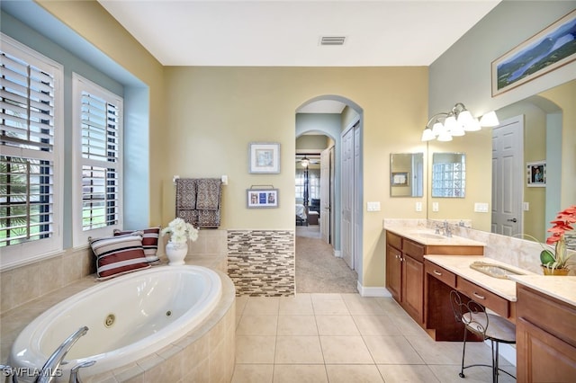 bathroom featuring tiled bath, tile patterned floors, and vanity