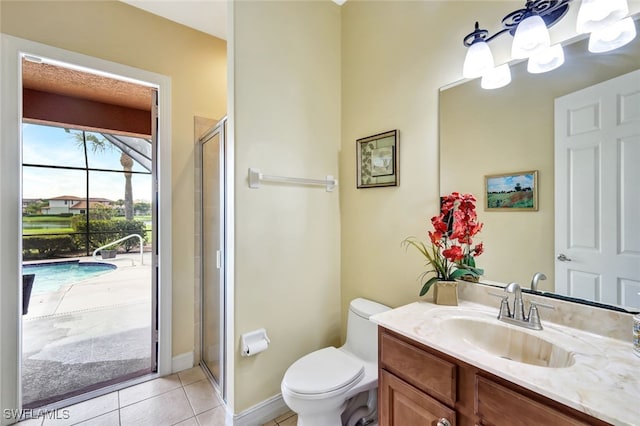 bathroom with a shower with shower door, vanity, tile patterned flooring, and toilet