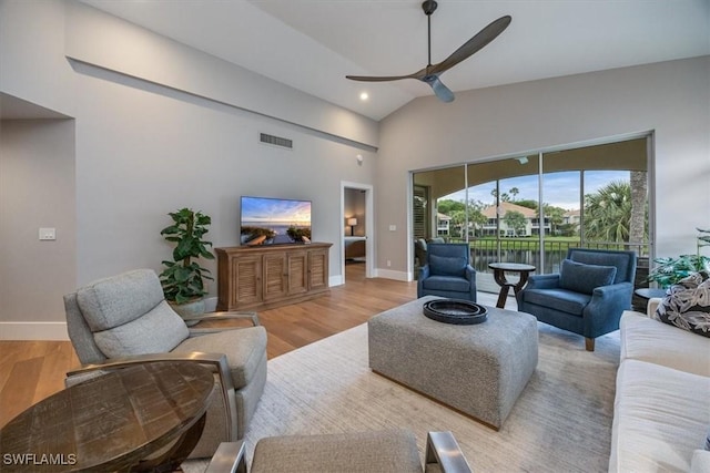 living room with ceiling fan, high vaulted ceiling, and light wood-type flooring