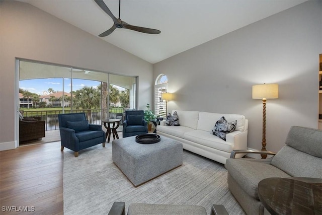 living room featuring ceiling fan, high vaulted ceiling, and light hardwood / wood-style floors