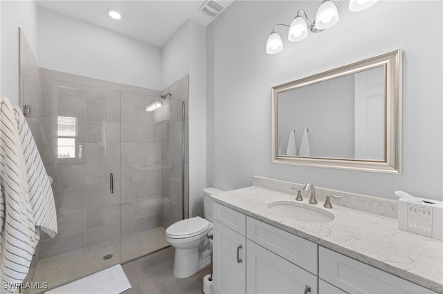 bathroom featuring vanity, toilet, and a shower with shower door