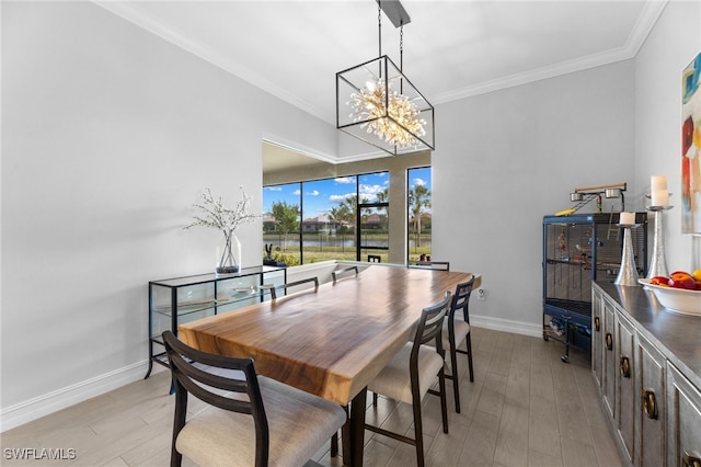 dining area with crown molding, light wood-type flooring, and an inviting chandelier