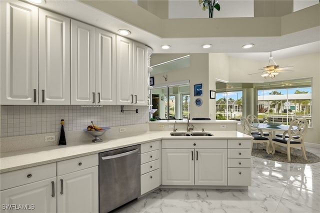 kitchen with a peninsula, a sink, marble finish floor, decorative backsplash, and dishwasher