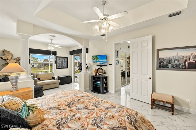 bedroom featuring arched walkways, marble finish floor, a raised ceiling, and decorative columns