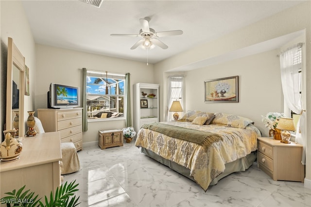 bedroom with ceiling fan, marble finish floor, and baseboards