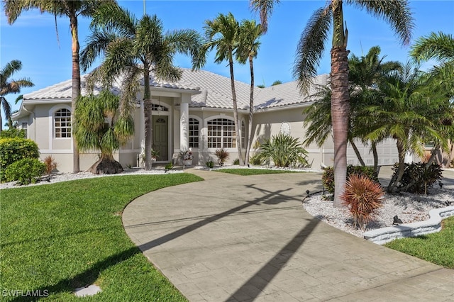 view of front of house featuring a garage, a tile roof, concrete driveway, and stucco siding