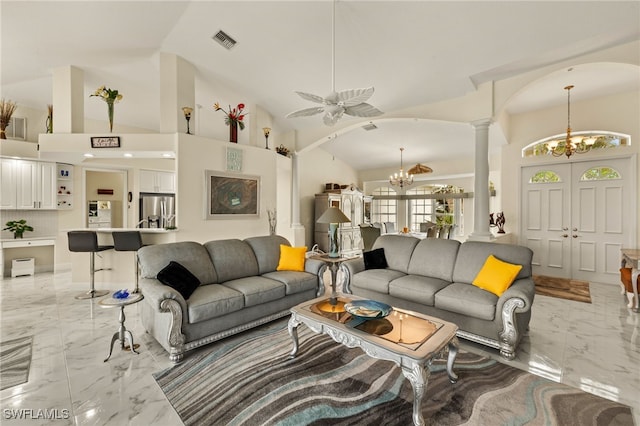 living room with arched walkways, marble finish floor, visible vents, and ornate columns