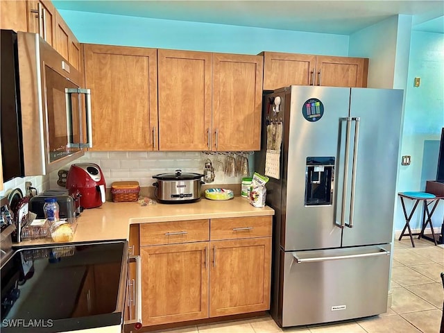 kitchen featuring backsplash, stainless steel appliances, and light tile patterned floors