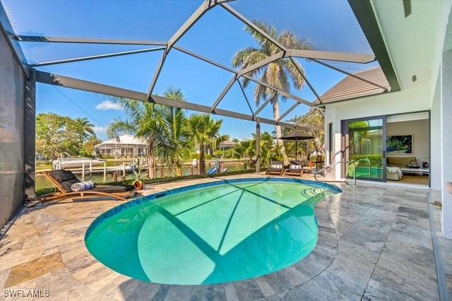 outdoor pool featuring a patio area and glass enclosure