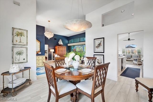 dining room featuring baseboards, a notable chandelier, and light wood finished floors