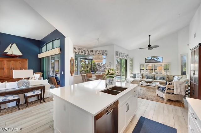 kitchen with open floor plan, light countertops, white cabinetry, and dishwasher