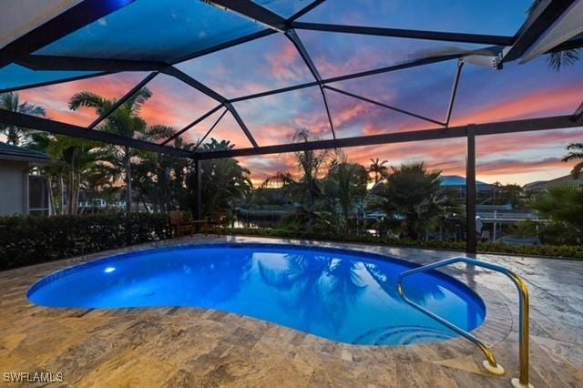 pool with glass enclosure and a patio