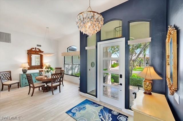 interior space featuring visible vents, a notable chandelier, and wood finished floors