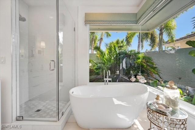 bathroom with a shower stall and a freestanding bath